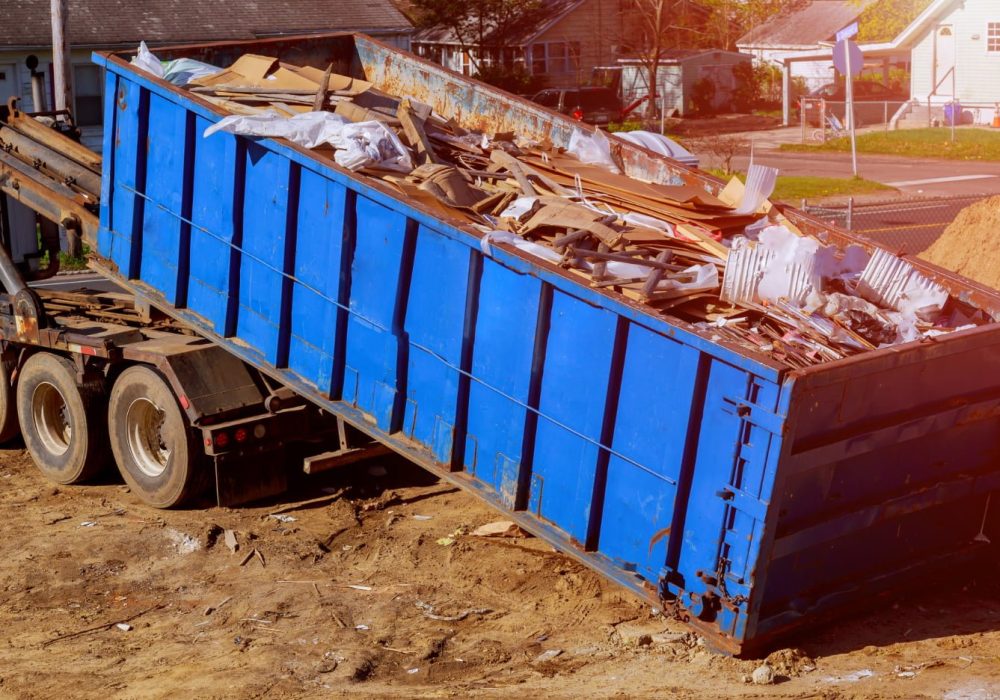 blue-construction-debris-container-filled-with-rock-concrete-rubble