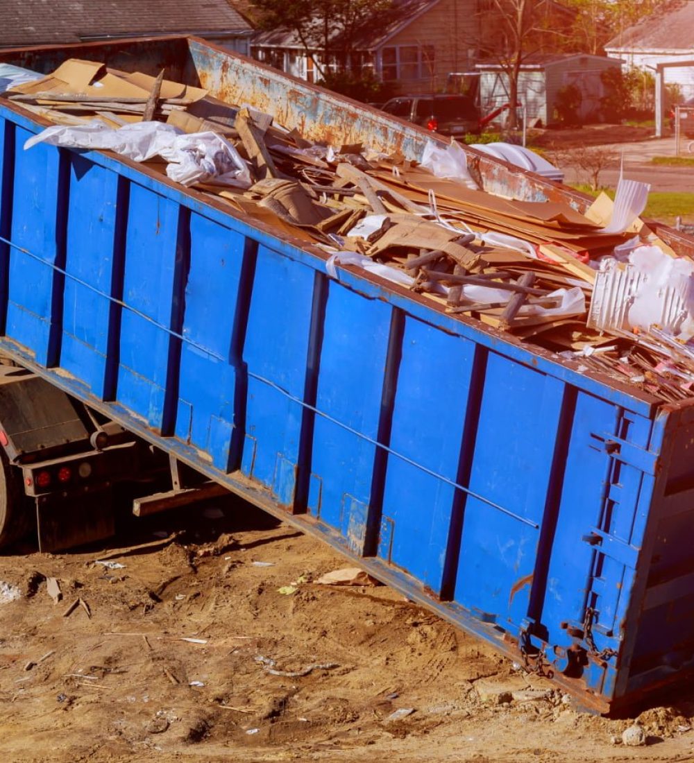 blue-construction-debris-container-filled-with-rock-concrete-rubble